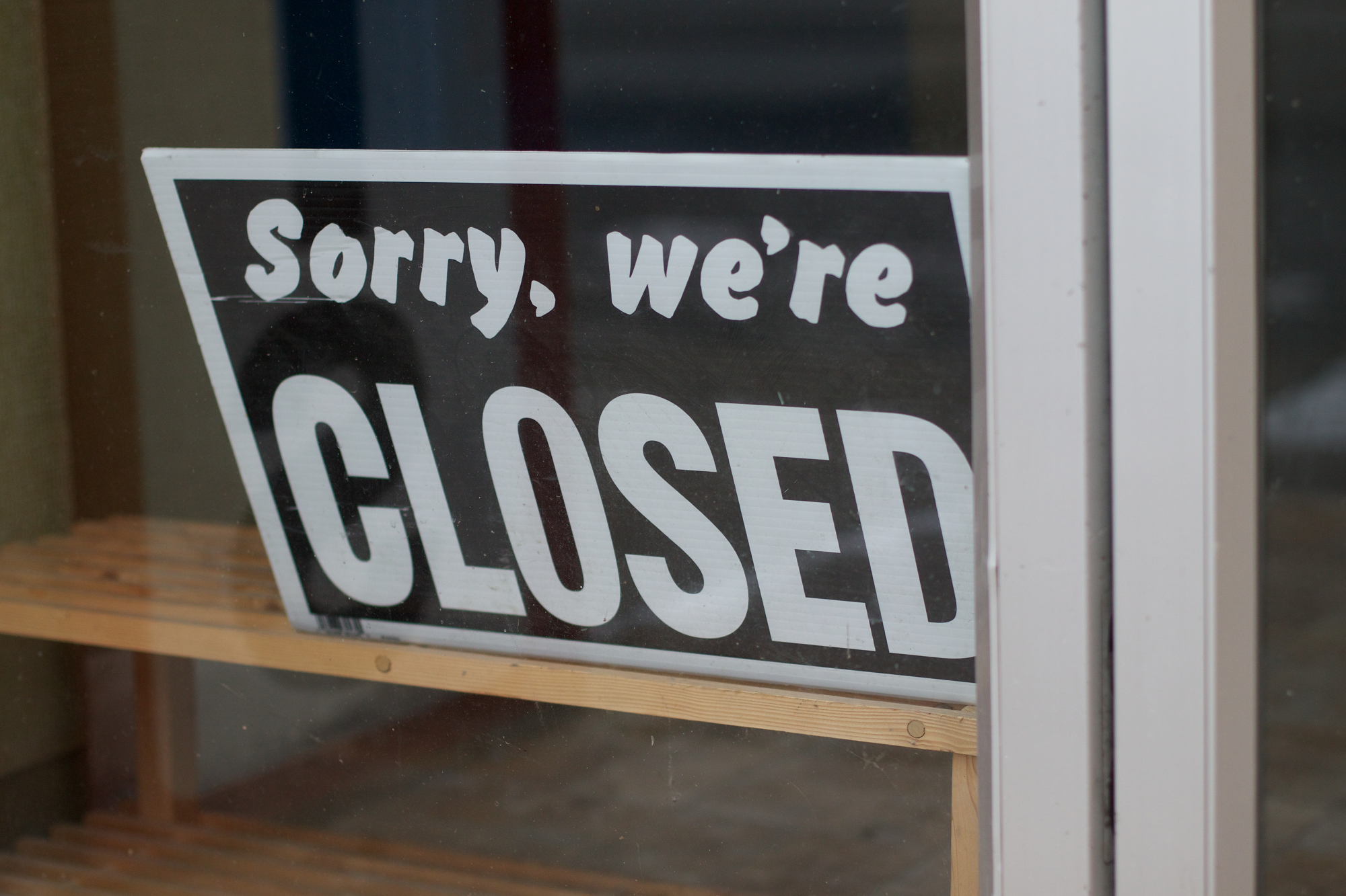 An image showing a shop sign that says 'Sorry, we're closed'