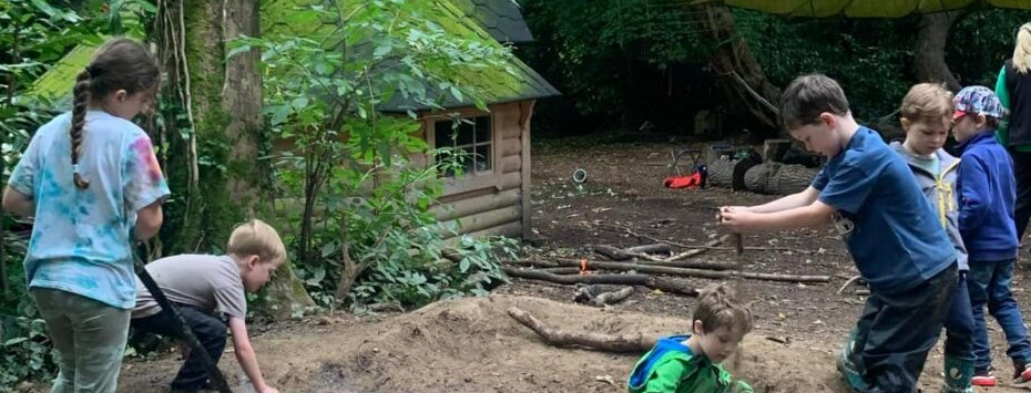 A photograph showing primary school children learning in a forest environment