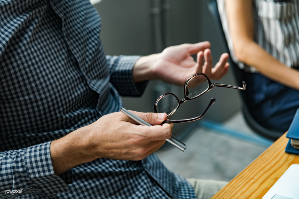 Photograph showing a man’s upturned hands during a professional meeting.